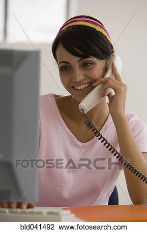Young woman talking on telephone View Large Photo Image Stock Image - Young woman talking on telephone. Fotosearch
