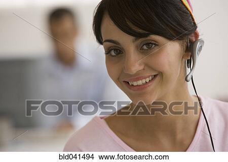 Picture - Young woman wearing headset. Fotosearch