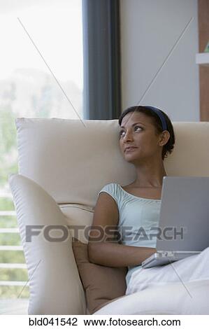 Young woman with laptop looking to side View Large Photo Image Stock Image - Young woman with laptop looking to side. Fotosearch