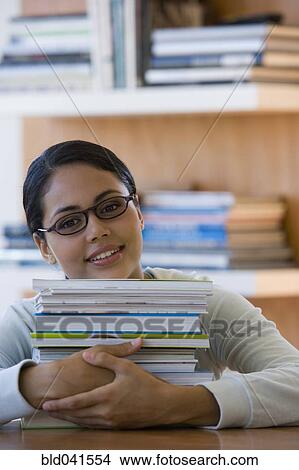 Picture - Young woman with stack of books. Fotosearch