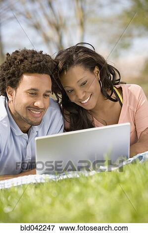 Stock Photo - African American couple looking at laptop. Fotosearch