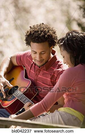 African American man playing guitar for girlfriend View Large Photo Image Stock Photo - African American man playing guitar for girlfriend. Fotosearch