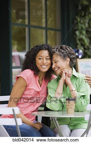 Picture - African American mother and adult daughter hugging. Fotosearch