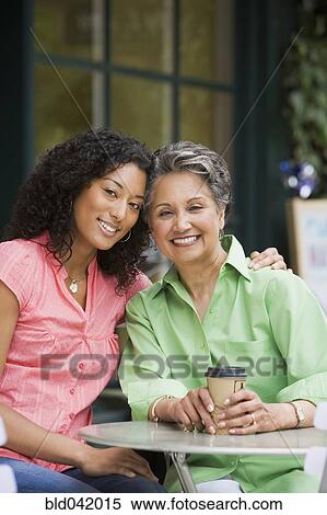 Stock Photography - African American mother and adult daughter hugging. Fotosearch