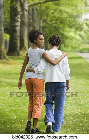 Stock Photography - African American mother and adult daughter hugging. Fotosearch