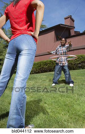 Stock Image - African boy playing with hula hoops. Fotosearch