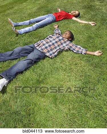 Stock Image - African mother and son laying in grass. Fotosearch