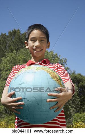 Stock Image - Asian boy holding globe. Fotosearch
