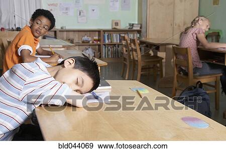 Stock Photo - Asian boy sleeping in classroom. Fotosearch