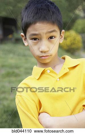Stock Image - Asian boy with arms crossed. Fotosearch
