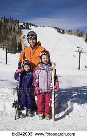 Stock Image - Asian mother and daughters in ski gear. Fotosearch
