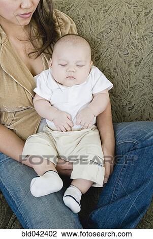 Asian mother holding sleeping baby View Large Photo Image Stock Image - Asian mother holding sleeping baby. Fotosearch