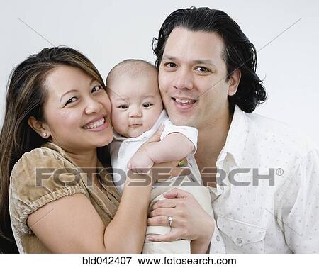 Asian parents hugging baby View Large Photo Image Stock Photo - Asian parents hugging baby. Fotosearch