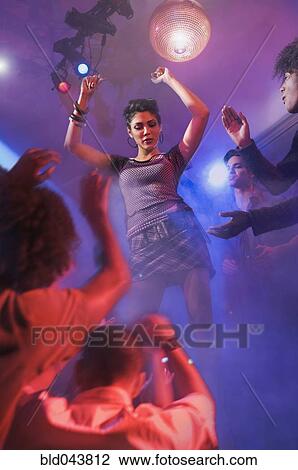 Stock Image - Asian woman dancing at nightclub. Fotosearch
