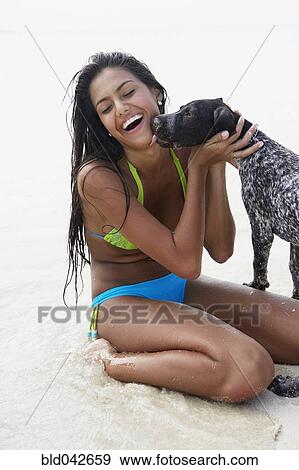 Dog licking South American woman at beach View Large Photo Image Stock Photo - Dog licking South American woman at beach. Fotosearch