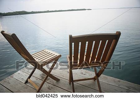 Stock Photography - Empty deck chairs on dock. Fotosearch