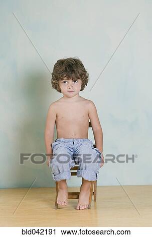 Hispanic boy sitting in chair View Large Photo Image Stock Image - Hispanic boy sitting in chair. Fotosearch