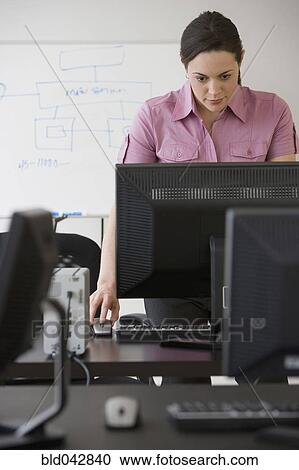 Stock Image - Hispanic businesswoman looking at computer. Fotosearch