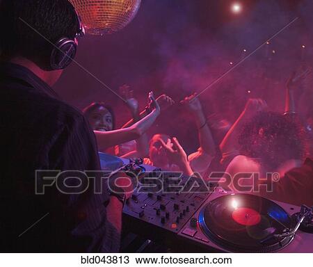 Stock Image - Hispanic dj playing at nightclub. Fotosearch