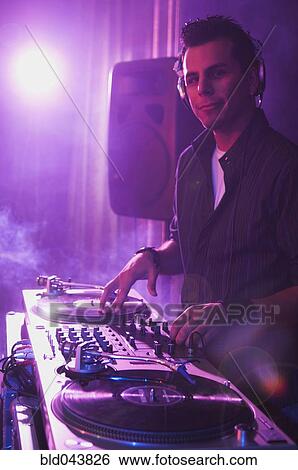 Stock Photograph - Hispanic dj playing at nightclub. Fotosearch
