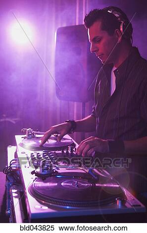 Stock Photography - Hispanic dj playing at nightclub. Fotosearch
