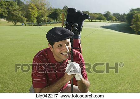 Hispanic man holding golf club View Large Photo Image Stock Photo - Hispanic man holding golf club. Fotosearch