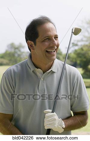 Hispanic man holding golf club View Large Photo Image Stock Photograph - Hispanic man holding golf club. Fotosearch