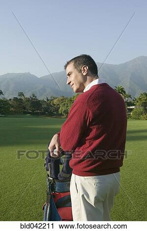 Stock Image - Hispanic man on golf course. Fotosearch