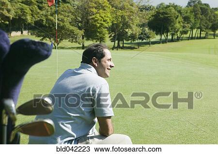 Stock Image - Hispanic man on golf course. Fotosearch