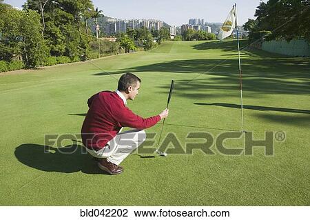 Stock Image - Hispanic man playing golf. Fotosearch