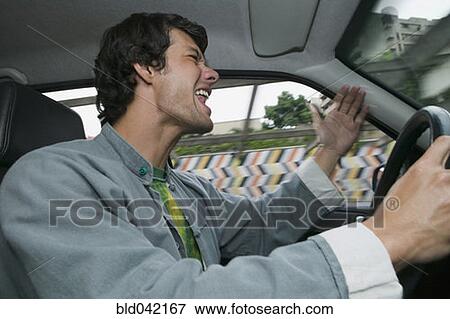 Stock Photo - Hispanic man yelling and driving. Fotosearch