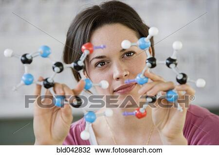 Stock Image - Hispanic woman holding molecular model. Fotosearch