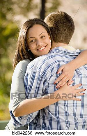Hispanic woman hugging boyfriend View Large Photo Image Stock Photograph - Hispanic woman hugging boyfriend. Fotosearch