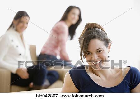 Stock Photo - Hispanic woman with friends in background. Fotosearch