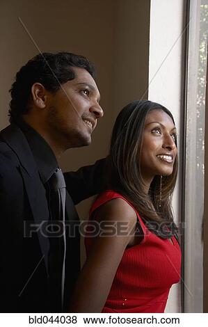 Stock Photo - Indian couple looking out window. Fotosearch