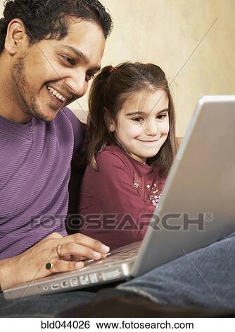 Indian father and daughter looking at laptop View Large Photo Image Stock Photograph - Indian father and daughter looking at laptop. Fotosearch