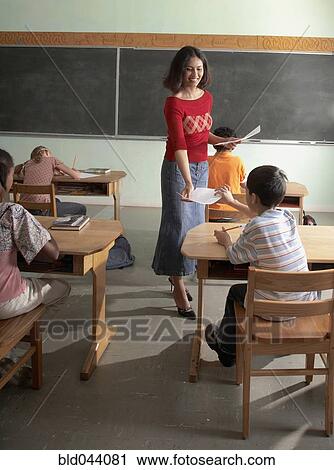 Indian female teacher handing back papers View Large Photo Image Stock Image - Indian female teacher handing back papers. Fotosearch
