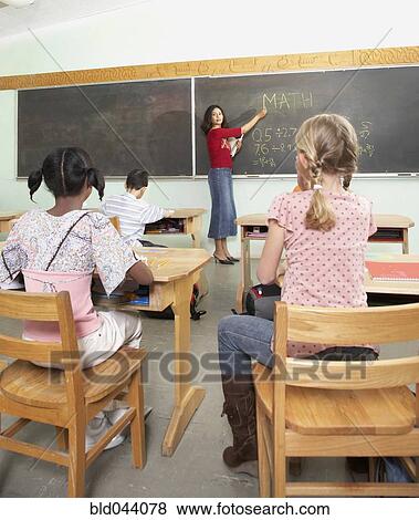 Indian female teacher pointing to blackboard View Large Photo Image Stock Photo - Indian female teacher pointing to blackboard. Fotosearch