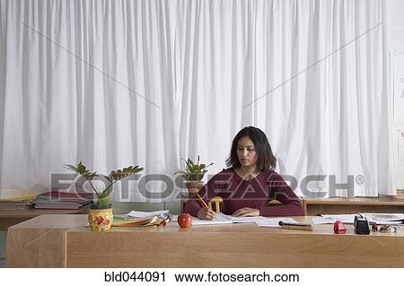 Indian female teacher writing at desk View Large Photo Image Stock Image - Indian female teacher writing at desk. Fotosearch