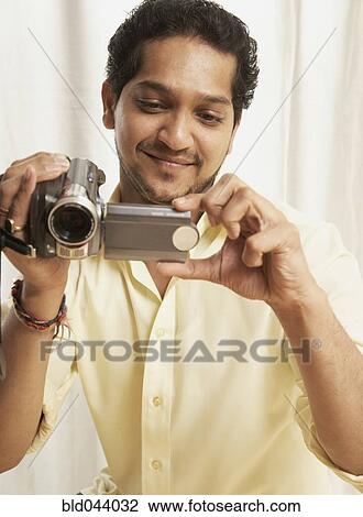 Indian man holding video camera View Large Photo Image Stock Image - Indian man holding video camera. Fotosearch