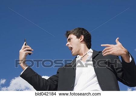 Picture - Man yelling at cell phone. Fotosearch