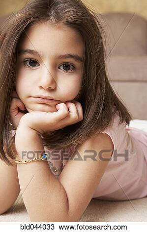 Stock Image - Middle Eastern girl laying on floor. Fotosearch