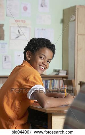 Mixed Race boy writing in classroom View Large Photo Image Stock Photo - Mixed Race boy writing in classroom. Fotosearch
