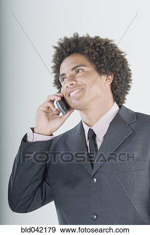 Stock Photo - Mixed Race businessman talking on cell phone. Fotosearch