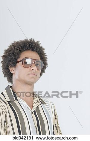 Stock Image - Mixed Race man wearing sunglasses. Fotosearch