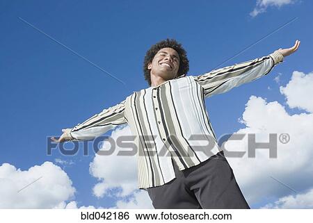 Mixed Race man with arms outstretched View Large Photo Image Stock Photograph - Mixed Race man with arms outstretched. Fotosearch
