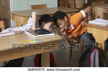 Multi-ethnic boys whispering in class View Large Photo Image Stock Image - Multi-ethnic boys whispering in class. Fotosearch
