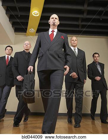 Stock Photo - Multi-ethnic businessmen walking in formation. Fotosearch