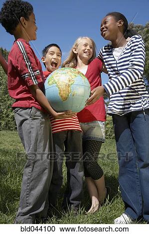 Stock Image - Multi-ethnic children holding globe. Fotosearch