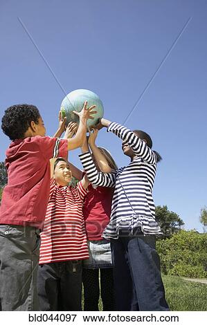 Stock Photo - Multi-ethnic children holding globe. Fotosearch